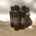 RoyalAllure Beauty Co & Apothecary hydrating shampoo bottles with black caps on a neutral surface