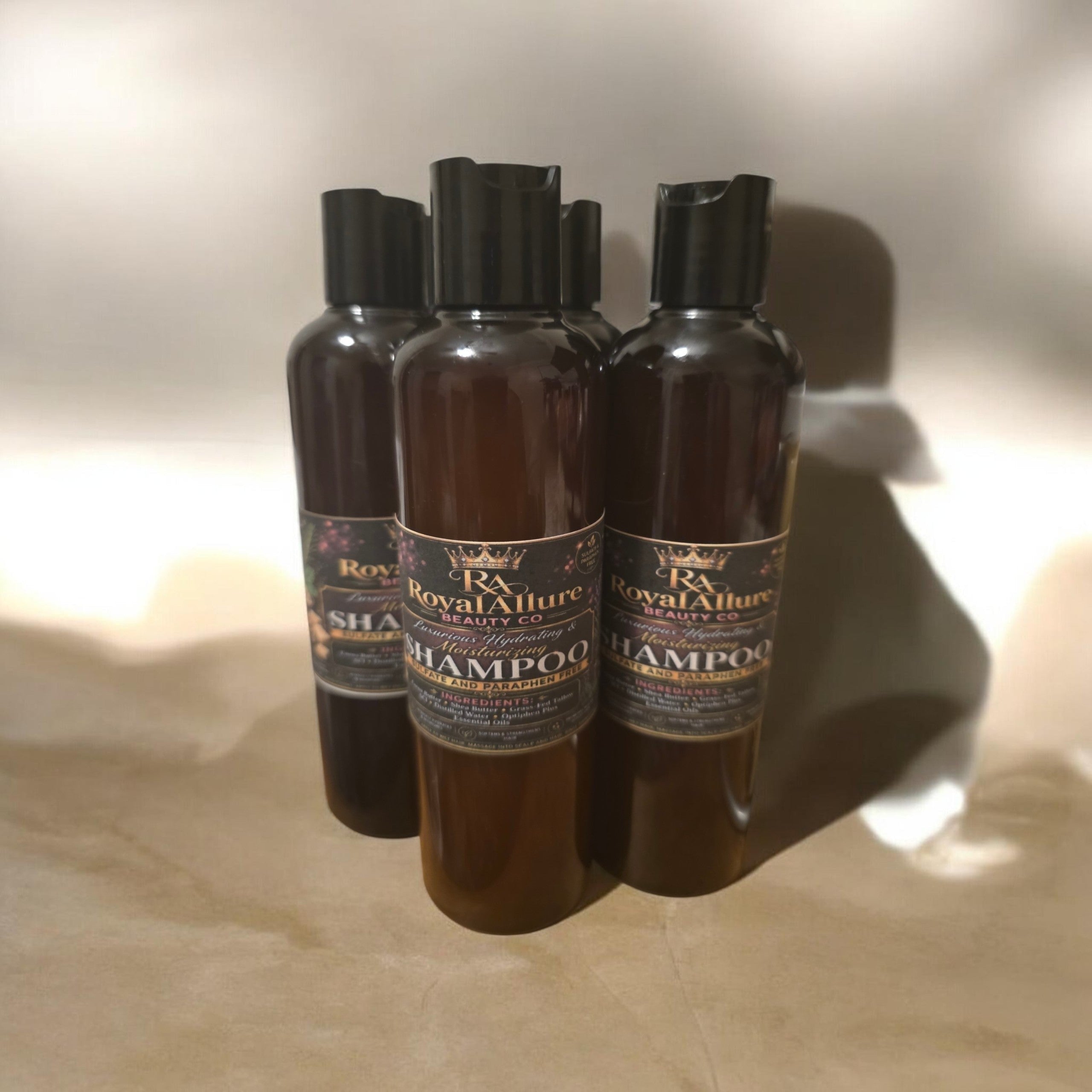 RoyalAllure Beauty Co & Apothecary hydrating shampoo bottles with black caps on a neutral surface